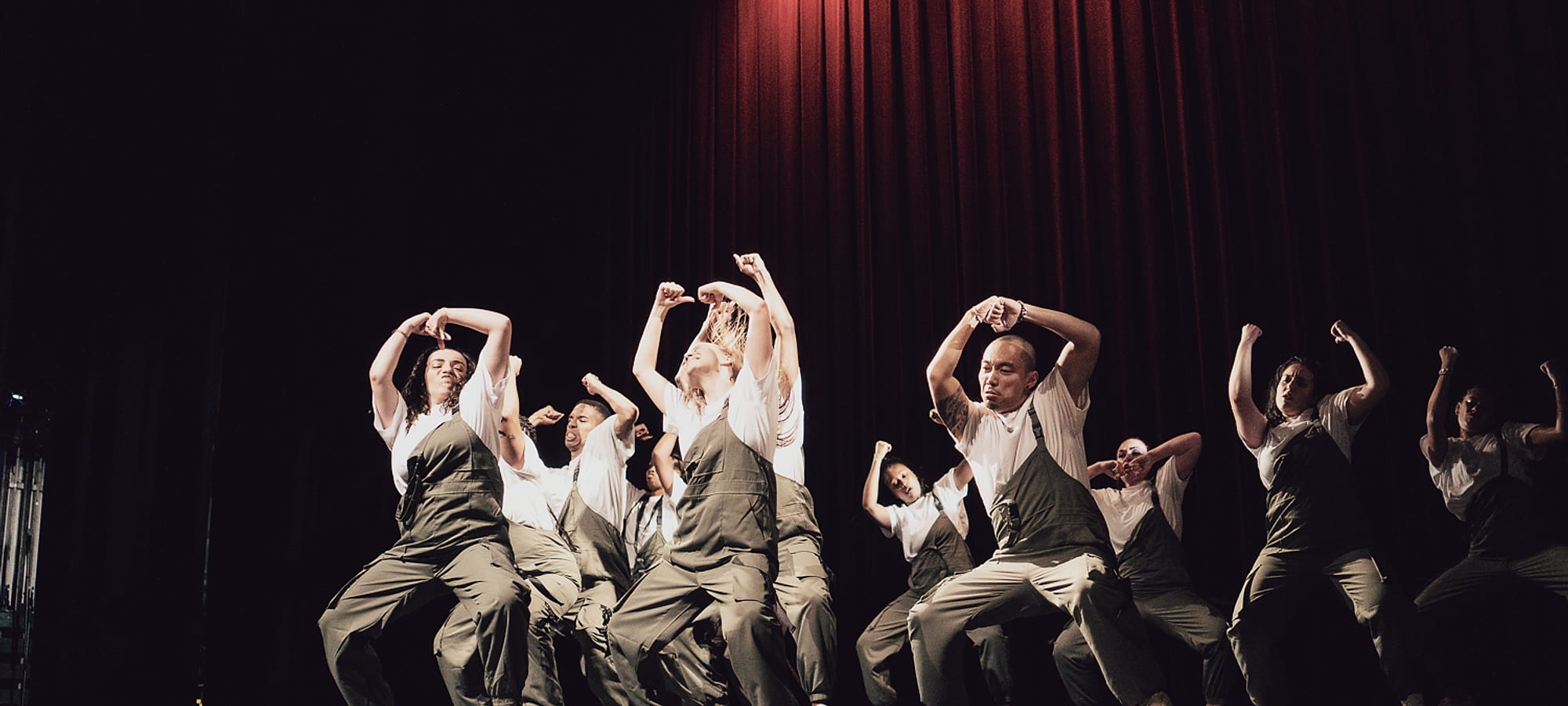 Yi et son groupe de danse sur scène, bras levés, en plein mouvement.